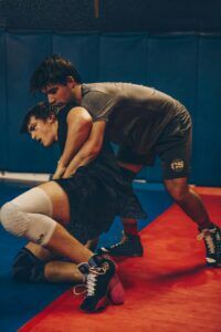 Two male wrestlers engaged in a competitive match in an indoor gym setting.